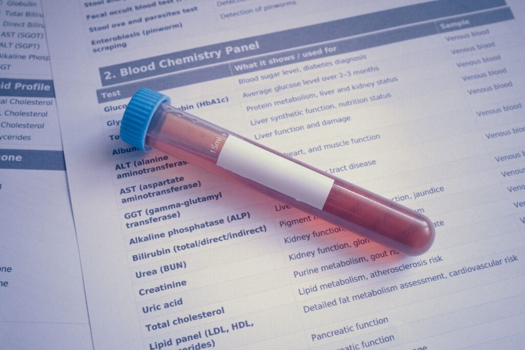 Kidney Function Screening Test A blood sample tube placed on a chemistry panel document, showcasing medical testing.