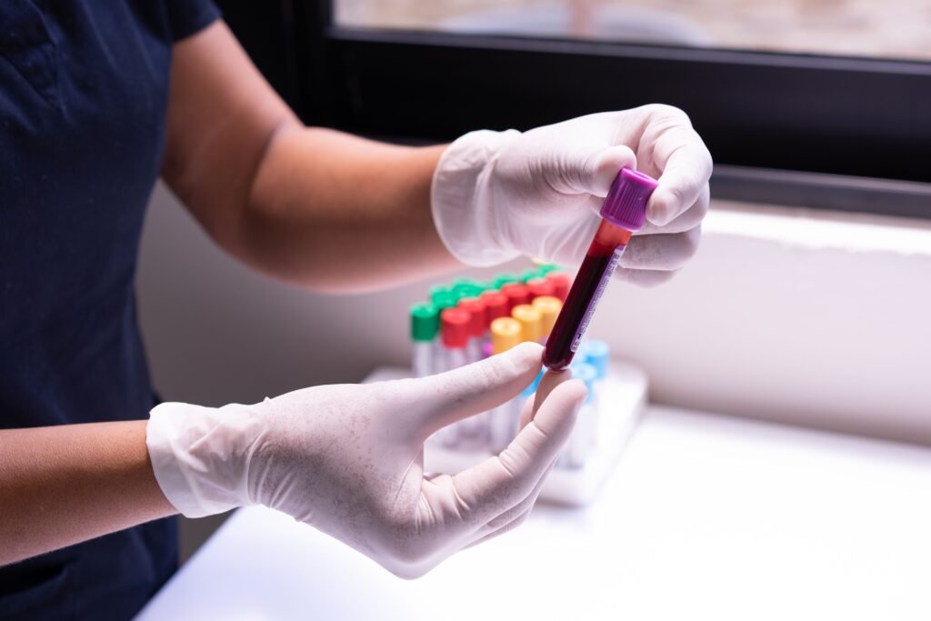 Child Health Checkup Package Gloved hands carefully handling a blood sample in a medical or laboratory environment.