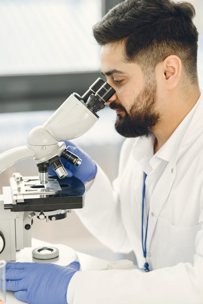 Male Infertility Test (MIT) A scientist focused on examining samples through a microscope in a laboratory setting, showcasing scientific research and discovery.